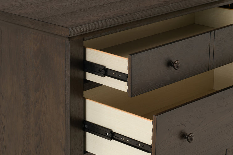 Wooden dresser with open drawers showing metal hardware